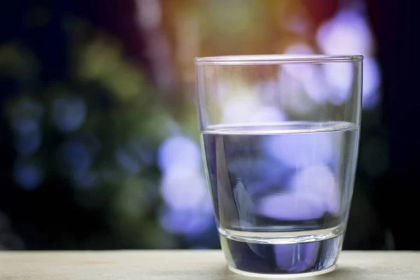 Bicchiere Acqua Sfondo Bokeh Verde Scuro — Foto Stock