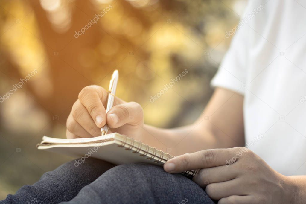 close up young women writing on notebook in park, concept in education and knowledge