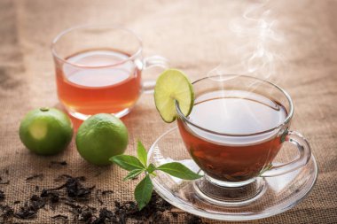 Fincan sıcak çay dilim limon üzerinde mola hızlı ve içme süresi sabah için kenevir çuval ile