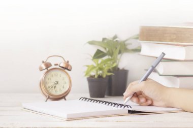 el yazısı not kağıdı çalar saat, bitki ve kitap ile çalışma masasında üzerinde