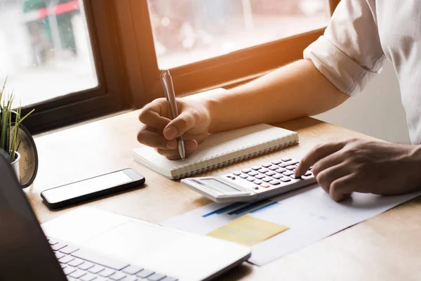 Escritura de hombre de negocios y la memoria en el cuaderno y calculadora en la ficha — Foto de Stock