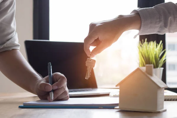 Key of home on hand of bank employeer  to sell house after appro — Stock Photo, Image