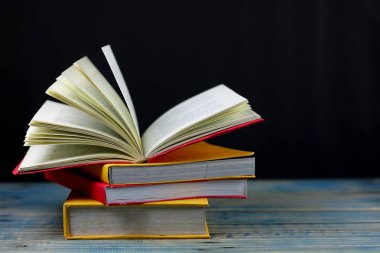 kitap üzerinde ahşap masa ve siyah arka plan, kağıt açmak olarak kavram kendi başına öğrenme dünyanın bilgisine bakın ve her yerde hayatını geliştirmek