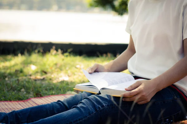 Jonge vrouwen lezen boek in park, concept in kennis en educa — Stockfoto