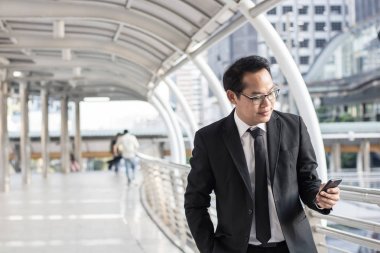 Mutlu ve memnun işadamı telefon tutarak