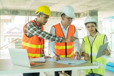 İnşaat alanındaki uçak projesinde dizüstü bilgisayarı olan genç mimarla birlikte profesyonel mühendis planlaması.
