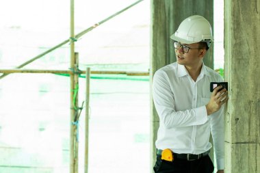 Müfettiş inşaat alanındaki direğin mesafesini kontrol ediyor. 