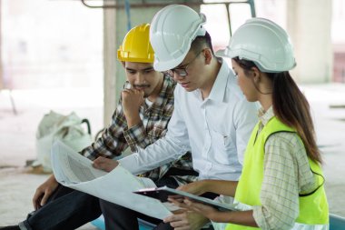 Mühendis ekibi mavi baskı projesini planlıyor ve kontrol ediyor.