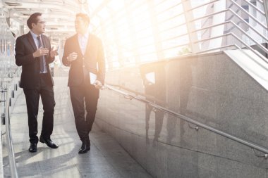 İş adamlarından oluşan bir ekip, ofisin önünde konuşuyor ve tartışıyorlar.