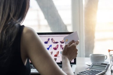 Bilgisayarda kredi kartı ve ödeme tutan kadın, online alışveriş kavramı 