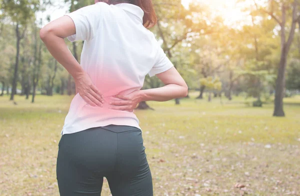 女运动员腰痛或受伤 在公园里锻炼 — 图库照片