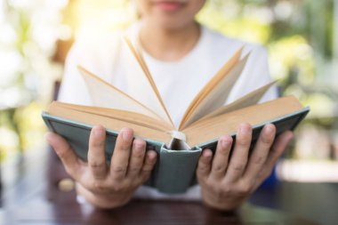 iki elle açılan bir kitap, bilgelik ve bilgi kavramı. 