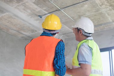 Planlama ve araştırma konsepti, iki işadamı inşaat alanına bakıyor ve inşaat hakkında tartışıyorlar.