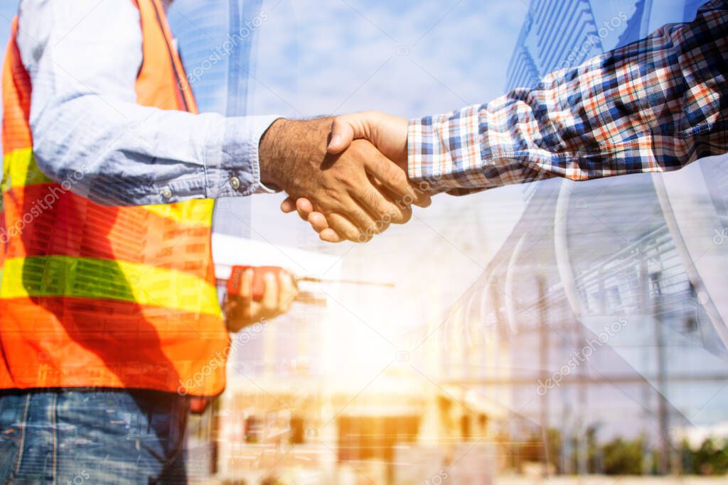 Architect contractor shaking hands with client at construction site 