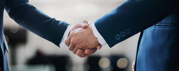 Başarılı sözleşme görüşmeleri ve tokalaşma konsepti, kutlama ortaklığı, takım çalışması, başarı iletişimi ve anlaşmadan sonra oda toplantısında iş anlaşması için iki iş adamı eşiyle tokalaşıyor.