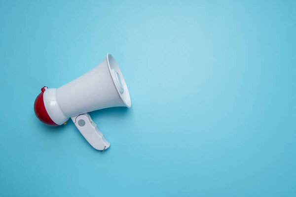 Megaphone announcement on blue background with copy space 