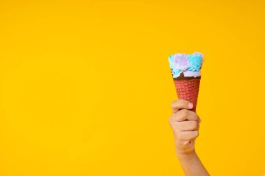 Sarı zemin üzerinde renkli dondurma külahını fotokopi alanı ile kapalı tut 