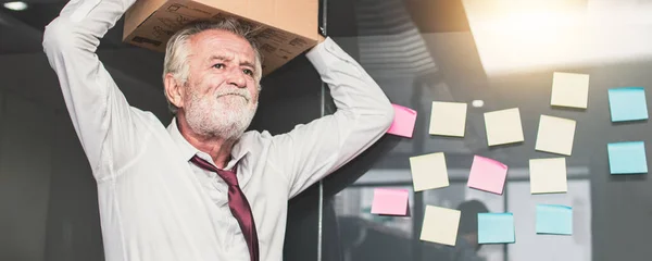 retirement and  lay off concept, old businessman preparing box and keeping objects out office. Frustration and loss work