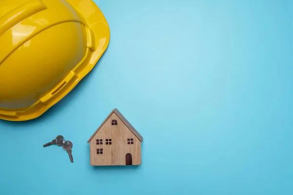 Casco Con Casa Madera Llave Sobre Fondo Azul Concepto Bienes —  Fotos de Stock