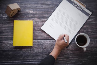 Gayrimenkul, ev satın almak ve ev konsepti satmak, banka temsilcisinin ofis masasının üstünde konut kredisi sözleşmesi ve ucuz faizli yeni anlaşma. 