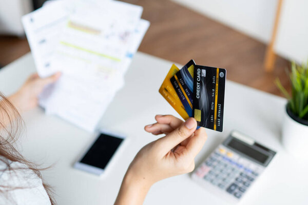 close up woman's hand holding three credit cards, feeling stressed about tax and debt problem from shopping online.