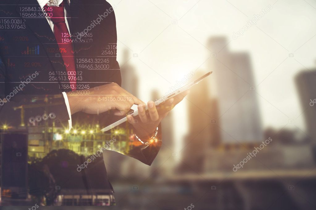 Double exposure of businessman using the tablet with cityscape a