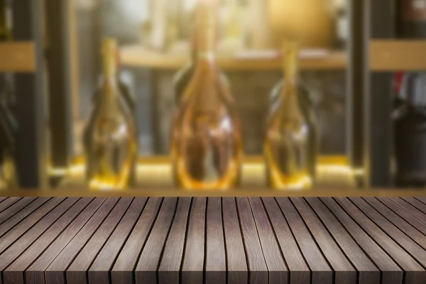 Wood table and wine Liquor bottle on shelf Blurred background ca — Stock Photo, Image