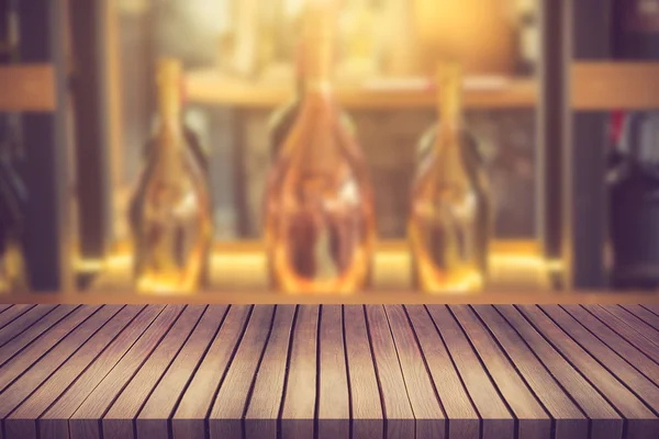 Wood table and wine Liquor bottle on shelf Blurred background ca — Stock Photo, Image