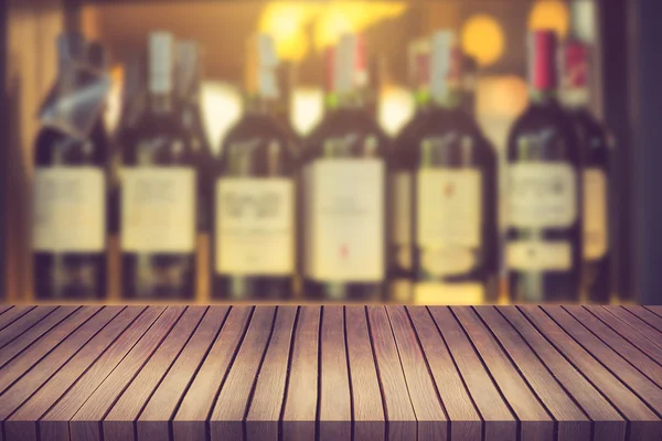 Wood table and wine Liquor bottle on shelf Blurred background ca — Stock Photo, Image