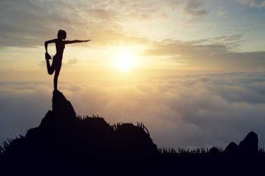 Pratik Yoga muontain üzerinde günbatımında siluet genç kadın