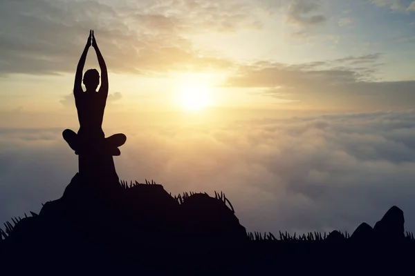 Silueta joven practicando yoga en el muontain al atardecer — Foto de Stock