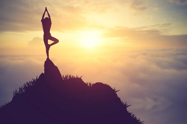 Pratik Yoga muontain üzerinde günbatımında siluet genç kadın — Stok fotoğraf