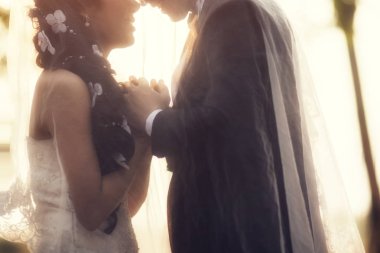 Çift holding düğün günbatımı arka plan üzerinde eller. Yumuşak odak