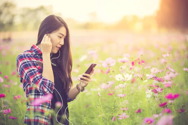 Unga hipster flicka Lyssna på musik i hörlurar i ett kosmos — Stockfoto