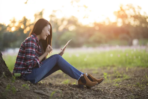 Euforisk kvinna söka jobb med en laptop i en stadspark i s — Stockfoto