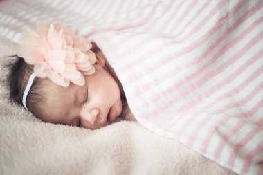 Yeni doğan şirin kız pembe bir arka plan üzerinde uyuyor. Vintage color.so