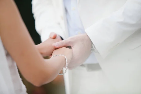 Les jeunes mariés échangent des bagues, le marié met la bague sur le han de la mariée — Photo