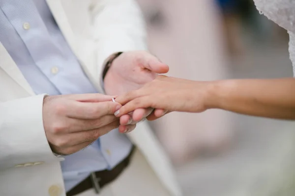 Pengantin baru saling bertukar cincin, pengantin pria meletakkan cincin di han pengantin wanita — Stok Foto