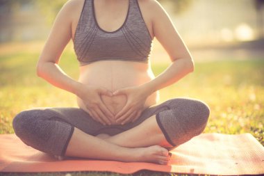 doğa açık havada yoga yaparken sağlıklı hamile kadın. Vintage col