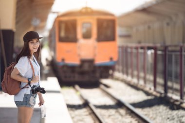 Tren demiryolu platformu üzerinde yürüyen Gezgin kadın ve bekler. Vinta