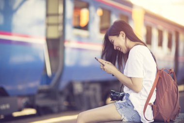 Tren demiryolu platformu üzerinde yürüyen Gezgin kadın ve bekler. Vinta