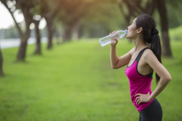 Жінка п'є воду з вправи . — стокове фото
