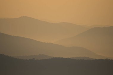 Gün batımında dağların ve sislerin katmanı