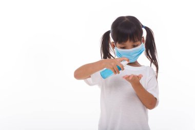 Beyaz arka planda alkol jeli kullanan küçük bir kız.