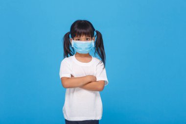 Koronavirüs salgınını korumak için solunum maskesi takan Asyalı küçük kız.