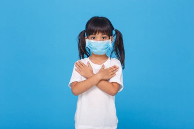 Koronavirüs salgınını korumak için solunum maskesi takan Asyalı küçük kız.