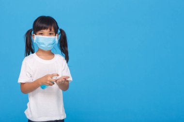 Maske takan sevimli Asyalı kız hastalığı beyaz arka planda yaymamak için ellerini alkolle yıkıyor. Grip virüsünün yayılmasının önlenmesi Koroner COVID-19 gribi