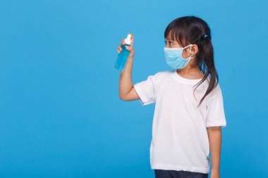 Maske takan sevimli Asyalı kız hastalığı beyaz arka planda yaymamak için ellerini alkolle yıkıyor. Grip virüsünün yayılmasının önlenmesi Koroner COVID-19 gribi