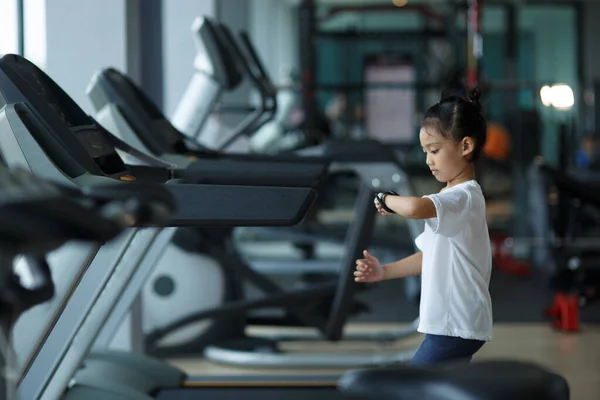 小さな女の子がトレッドミルを走っている 子供スポーツの概念 — ストック写真