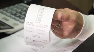 Stresli kadın faturaları, vergileri, banka hesaplarını kontrol ediyor ve evdeki oturma odasındaki harcamaları hesaplıyor.